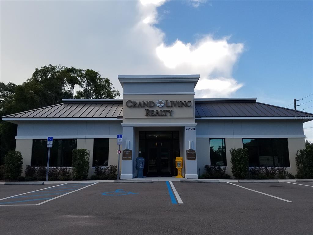 A single-story commercial building with a metal roof and a central entrance under a parapet — 2298 COLBERT LANE, PALM COAST, FL