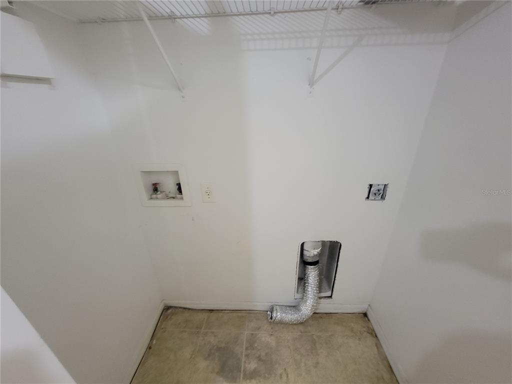 An empty laundry closet features a washer hookup box, dryer vent, and electrical outlet — 15755 SW 33RD AVE ROAD UNIT 1, OCALA, FL