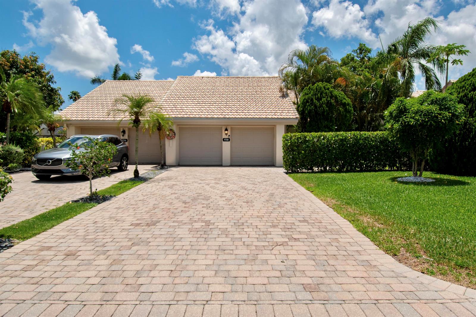 A paved driveway leads to a two-car garage of a house with a tiled roof — 9708 Erica Court, Boca Raton FL 33496, BOCA RATON, FL
