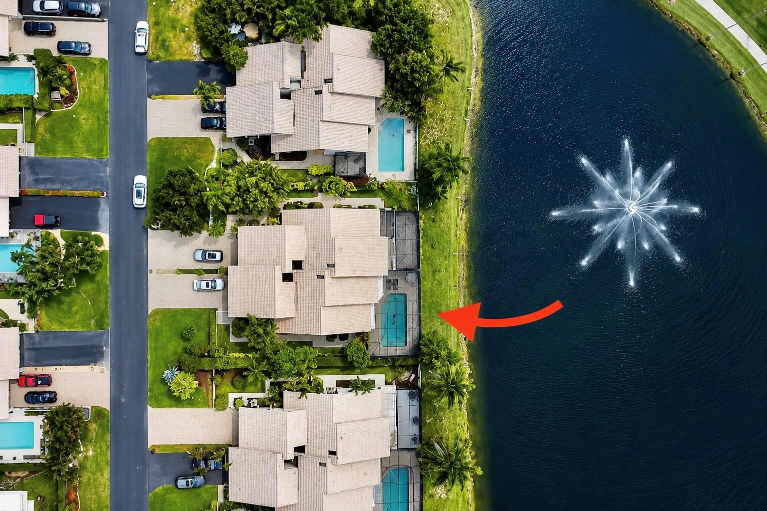 Aerial view of townhouses with private pools along a lake featuring a large water fountain — 9708 Erica Court, Boca Raton FL 33496, BOCA RATON, FL