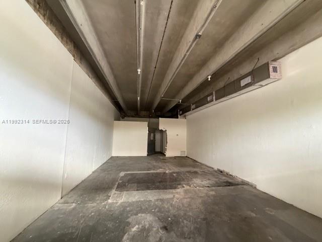 An empty commercial space features exposed concrete ceilings, white walls, and a dark concrete floor — 5650 NE 2nd Ave # A, Miami FL 33137, MIAMI, FL