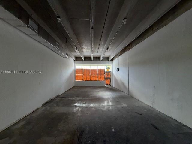 An empty commercial space features concrete floors, white walls, and an exposed industrial ceiling — 5650 NE 2nd Ave # A, Miami FL 33137, MIAMI, FL