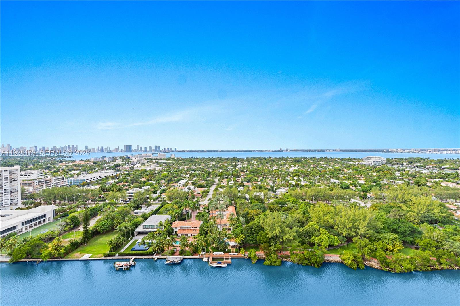 An aerial view shows a waterfront property with a pool, lush landscaping, and surrounding residential area — 4401 Collins Ave # 2517, Miami Beach FL 33140, MIAMI BEACH, FL