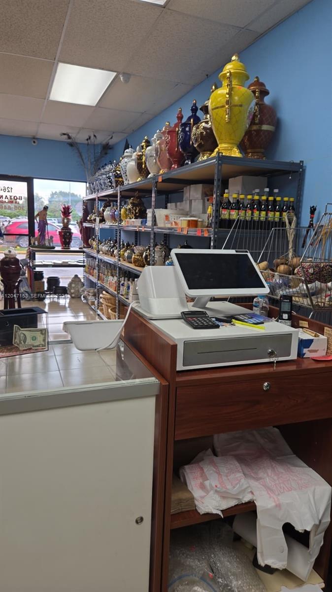 A retail store counter features a point-of-sale system with shelves of decorative vases behind it — MIAMI, FL