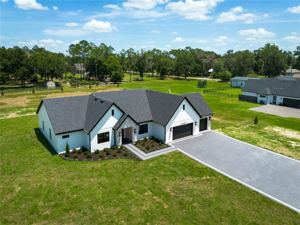 The exterior of a house features a stone-faced entryway with double doors and a walkway — 14800 MIM PLACE, DADE CITY, FL