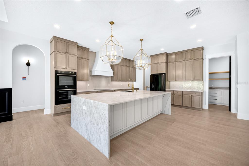 A modern single-story house with white stucco, stone accents, and a dark shingled roof — 14800 MIM PLACE, DADE CITY, FL