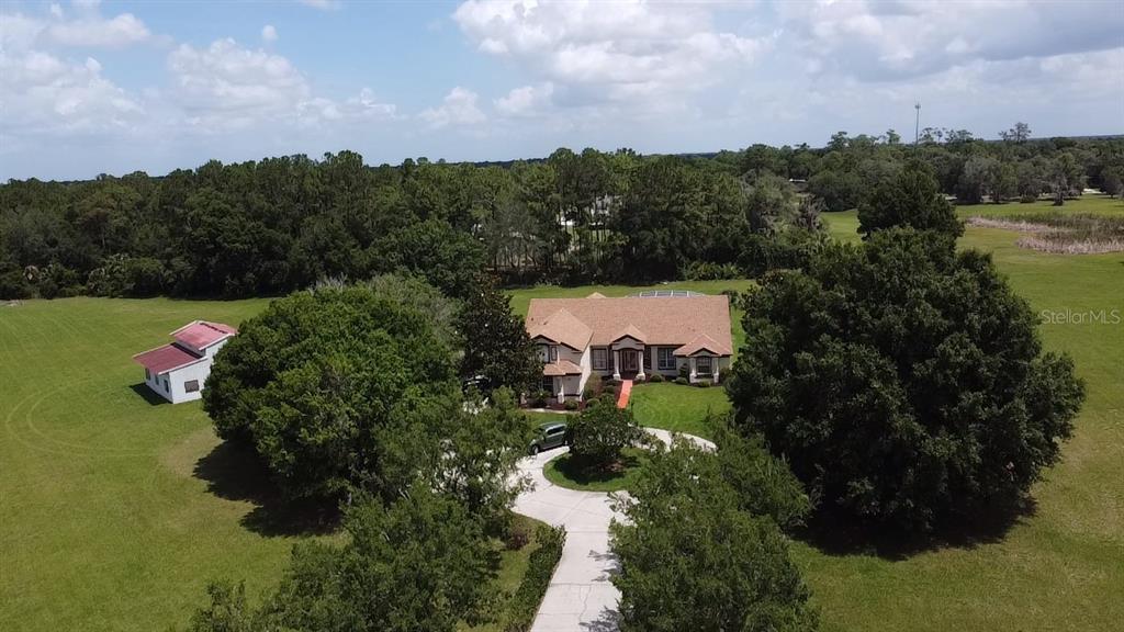 An aerial view shows a house with a circular driveway and a detached shed — 31405 BEAR POND DRIVE, SORRENTO, FL