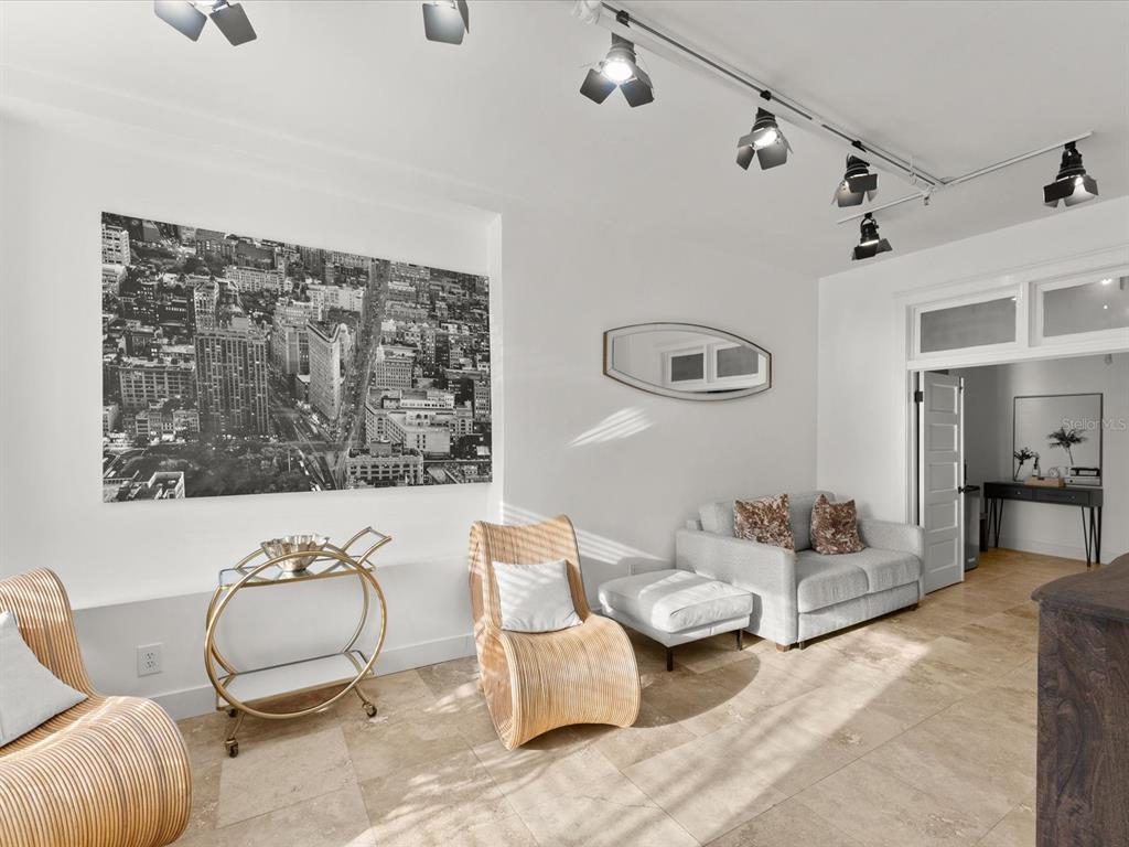 A living room features light tile floors, track lighting, two wicker chairs, and a sofa — 307 S PALMETTO AVENUE, DAYTONA BEACH, FL