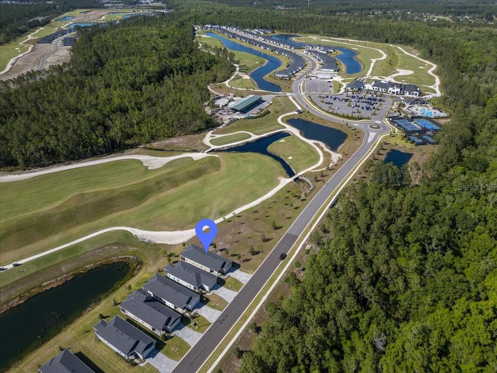 An aerial view shows a row of houses next to a golf course and ponds — 907 STILLWATER BOULEVARD, ST JOHNS, FL