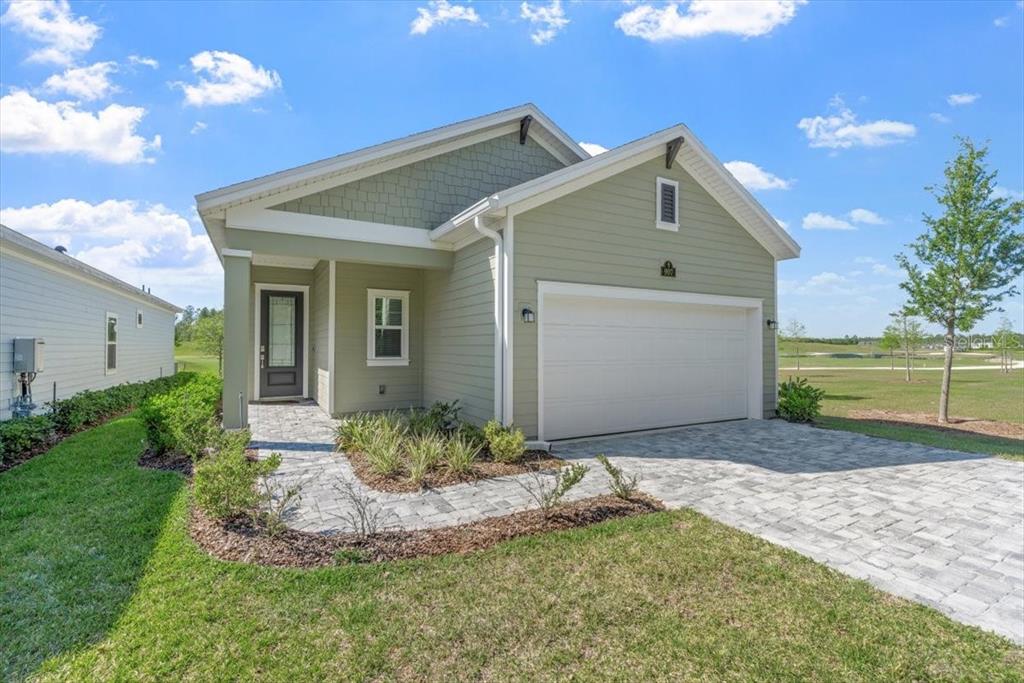 A light green single-story house with a two-car garage and a paved walkway — 907 STILLWATER BOULEVARD, ST JOHNS, FL