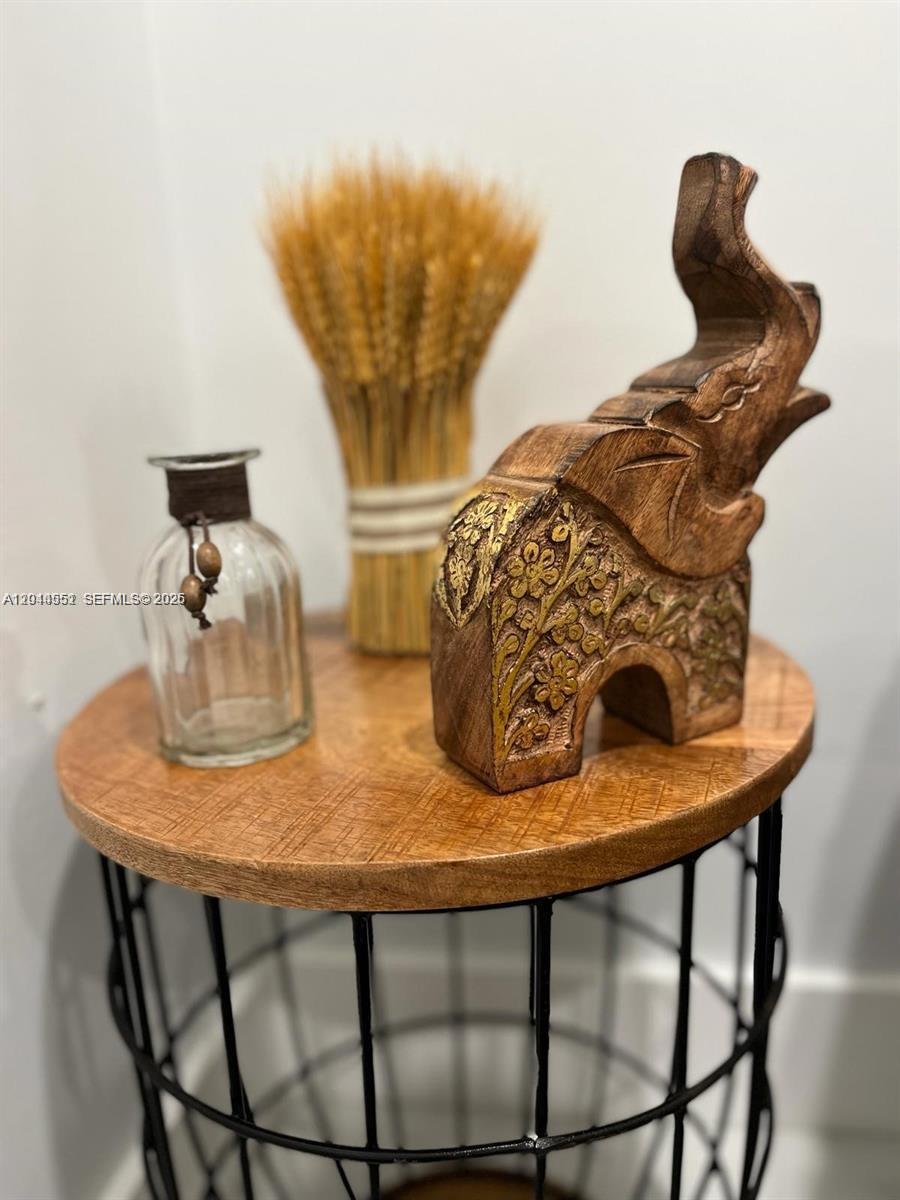 A wooden elephant figurine, a glass bottle, and a wheat bundle sit on a side table — MIAMI, FL