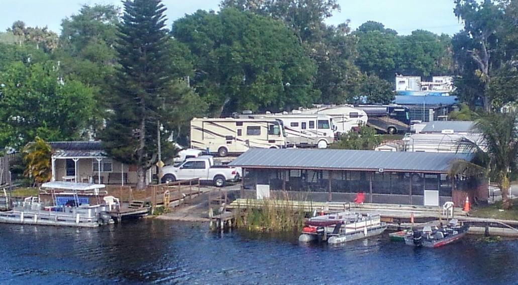 An aerial view shows a waterfront RV park with several parked motorhomes and docked boats — 4074 Hwy 441, Okeechobee FL 34971, OKEECHOBEE, FL