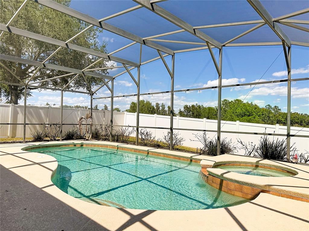 A single-story house with a tan stucco exterior, a brown front door, and a front lawn — 135 BLACKSTONE CREEK ROAD, GROVELAND, FL