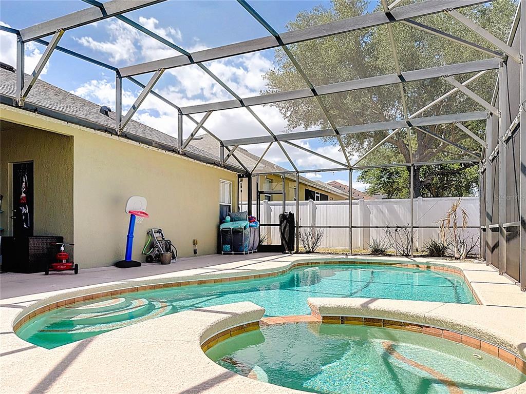 A single-story house with a tan stucco exterior, a front porch, and a landscaped yard — 135 BLACKSTONE CREEK ROAD, GROVELAND, FL