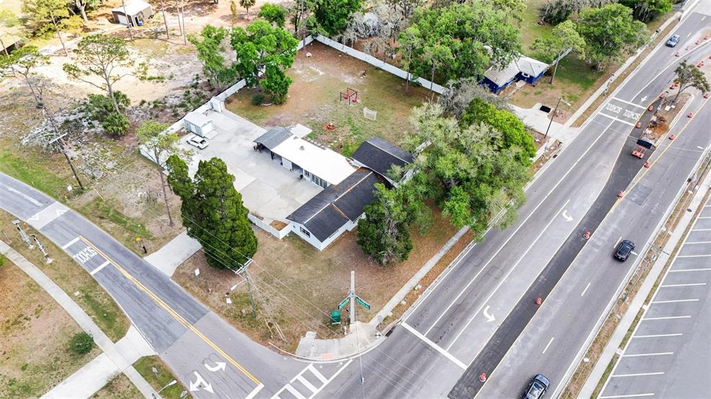 An aerial view shows a single-story building with a fenced yard near a road intersection — 3101 S KINGS AVENUE, BRANDON, FL