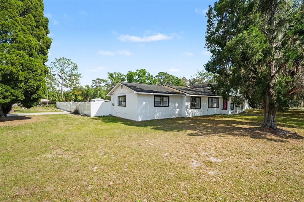 A white single-story house with a dark roof sits on a grassy lot with trees — 3101 S KINGS AVENUE, BRANDON, FL