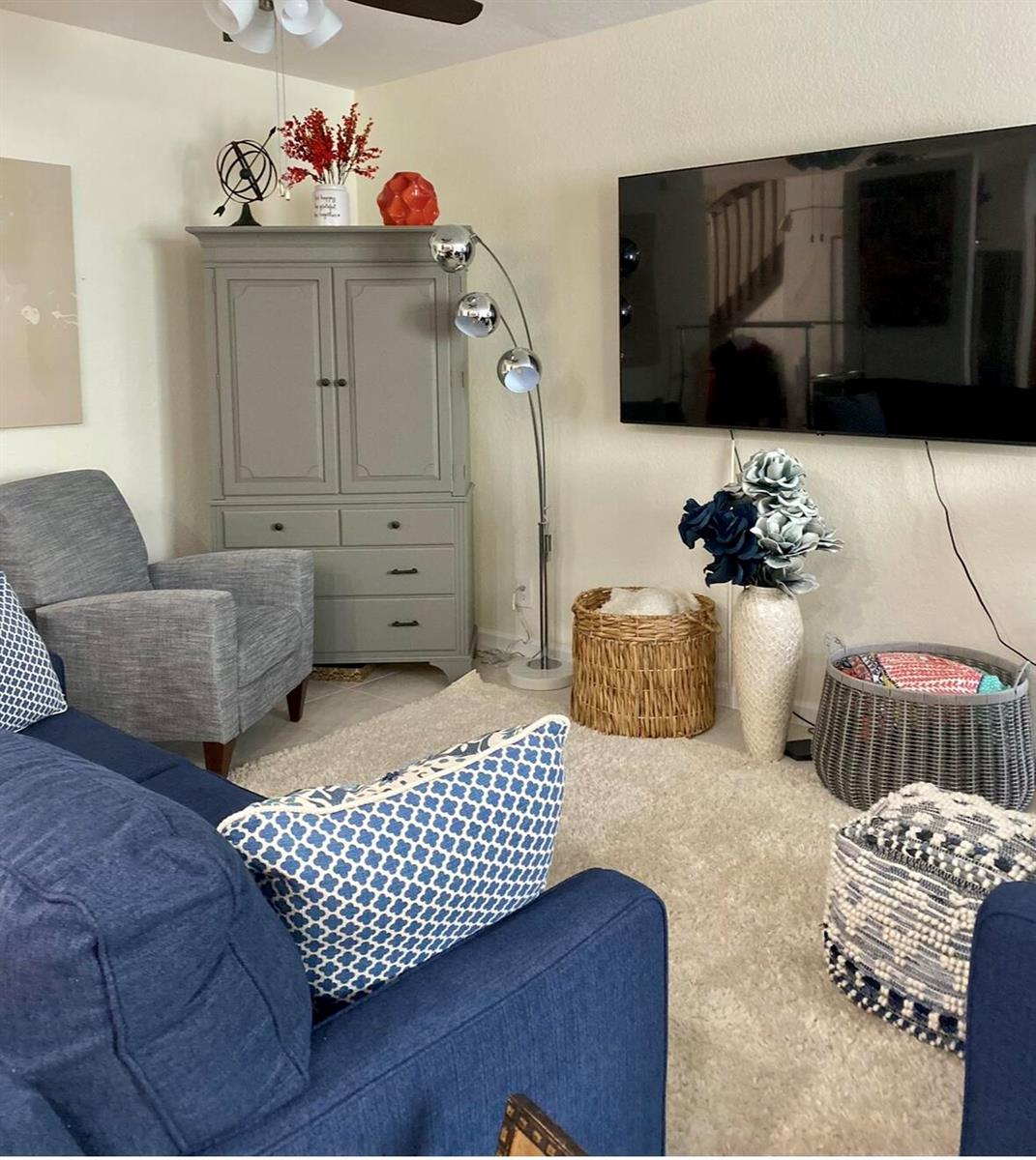 A living room features a blue sofa, a grey cabinet, a floor lamp, and a wall-mounted television — 2823 S Evergreen Circle, Boynton Beach FL 33426, BOYNTON BEACH, FL