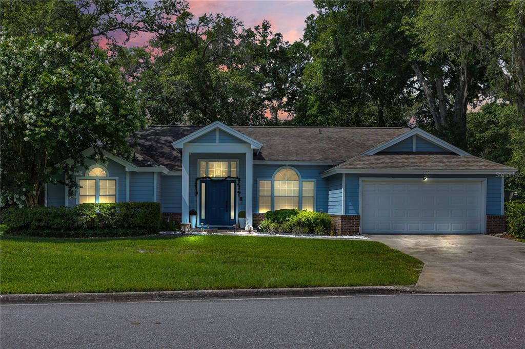 A single-story blue house with a two-car garage and a front porch at dusk — 170 OAK VIEW CIRCLE, LAKE MARY, FL