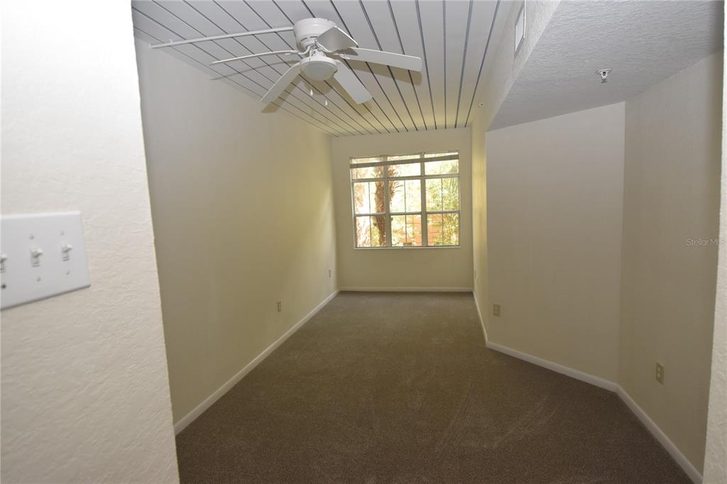 An empty room with beige carpet, white walls, and a ceiling fan with wood slats — 2402 W AZEELE STREET UNIT 426, TAMPA, FL