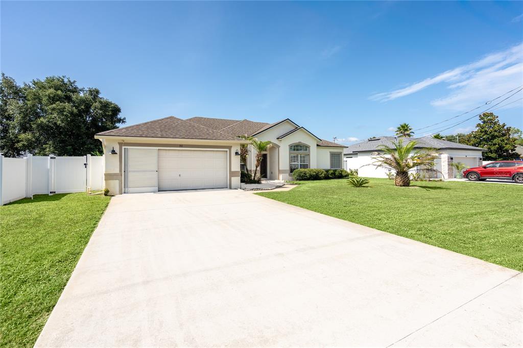 A single-story house with a two-car garage, a concrete driveway, and a front lawn — 50 ROLLING SANDS DRIVE, PALM COAST, FL