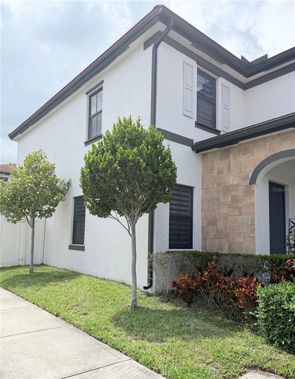 A two-story house exterior features white stucco walls, dark trim, and a stone-clad entryway — 10306 W 33RD LANE, HIALEAH, FL