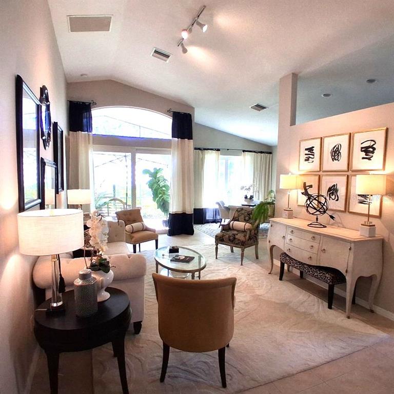 A living room features vaulted ceilings, a neutral color palette, and a white console table — 6642 41ST STREET CIRCLE E, SARASOTA, FL