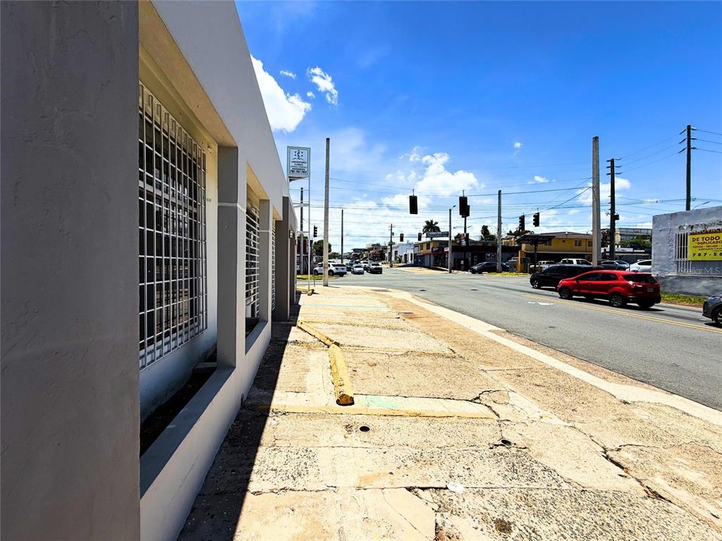 An exterior view of a building with a concrete sidewalk and a street with traffic — Z40 LAUREL AVENUE, BAYAMON, PR