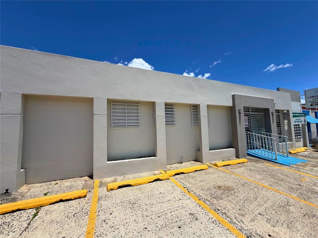 A low-rise commercial building with a concrete exterior, parking spaces, and a blue wheelchair ramp — Z40 LAUREL AVENUE, BAYAMON, PR