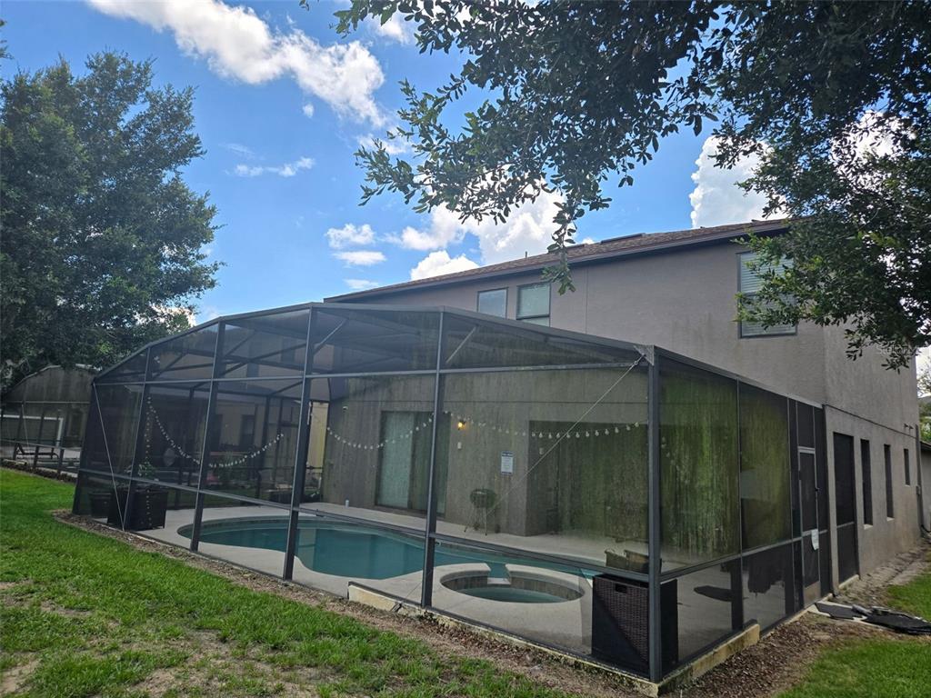 A two-story house with a screened-in pool and spa in the backyard — 1120 CYPRESS POINTE BOULEVARD, DAVENPORT, FL