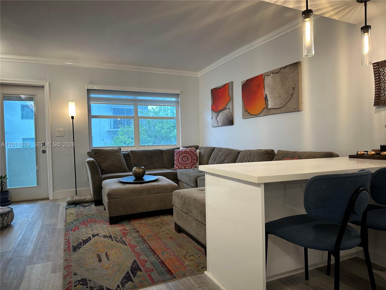 A living room features a gray sectional sofa, a patterned area rug, and a kitchen island — 1130 11th St # 4E, Miami Beach FL 33139, MIAMI BEACH, FL