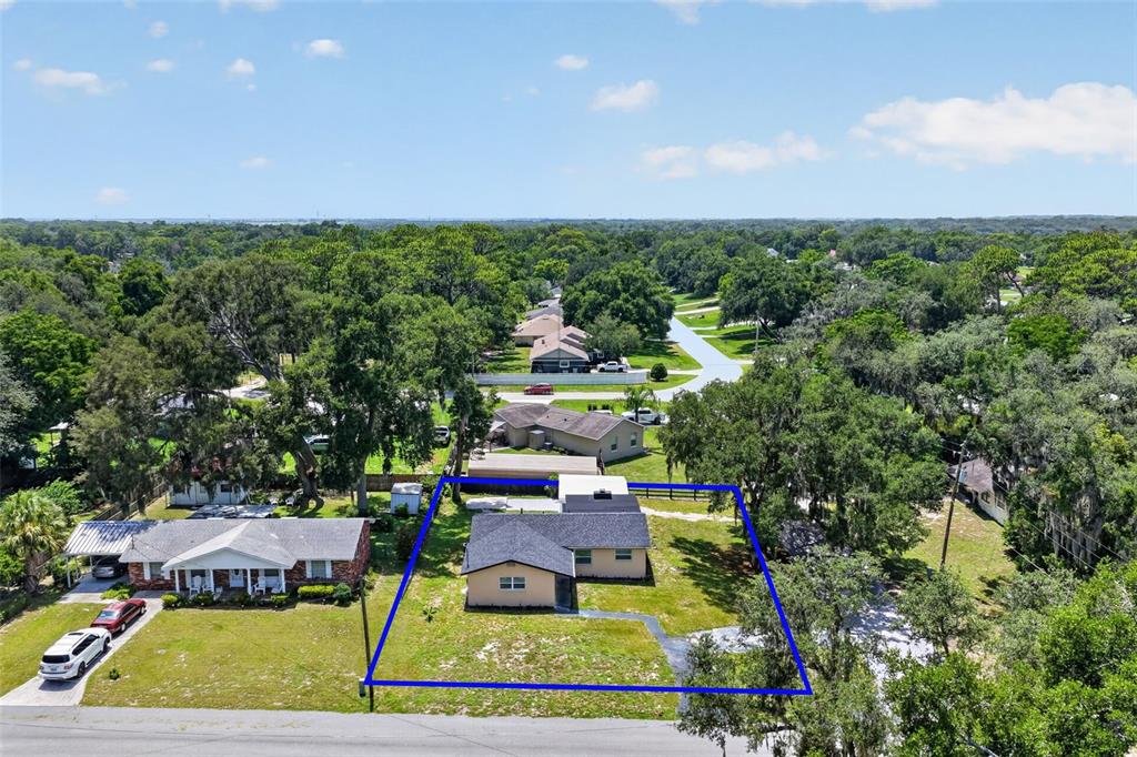 An aerial view shows a single-story house with a dark roof and a fenced yard — 708 CINDY AVENUE, FRUITLAND PARK, FL