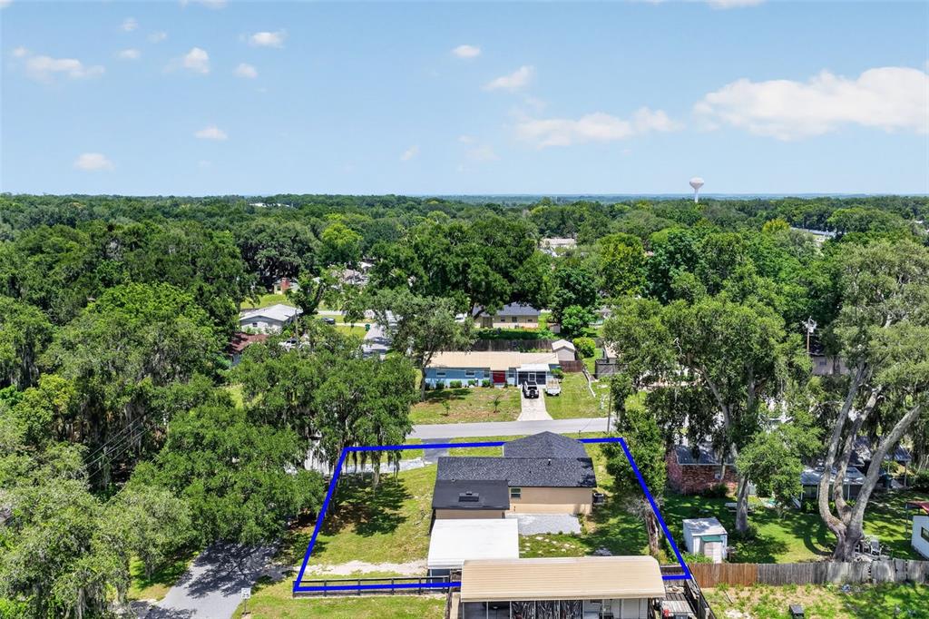 An aerial view shows a single-story house with a fenced yard and surrounding trees — 708 CINDY AVENUE, FRUITLAND PARK, FL
