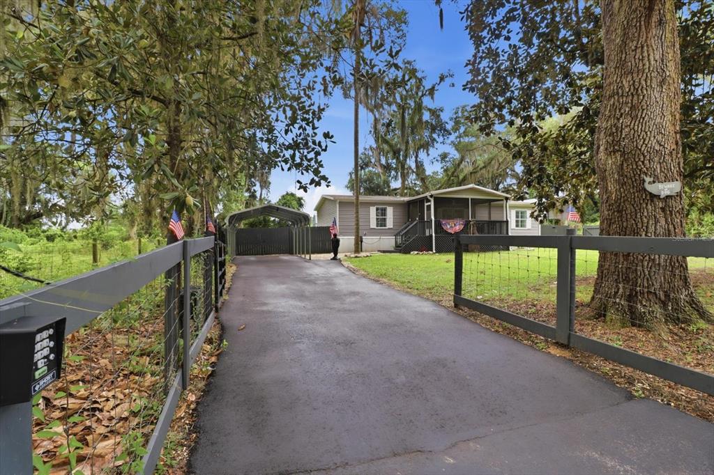 A paved driveway leads to a manufactured home with a carport and a fenced yard — 4370 E AMHERST STREET, HERNANDO, FL