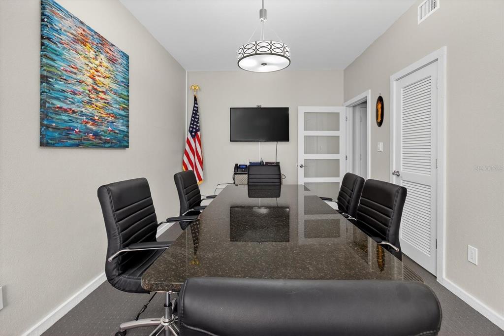 A conference room features a dark granite table, black leather chairs, and an American flag — 10225 ULMERTON ROAD UNIT 12B, LARGO, FL