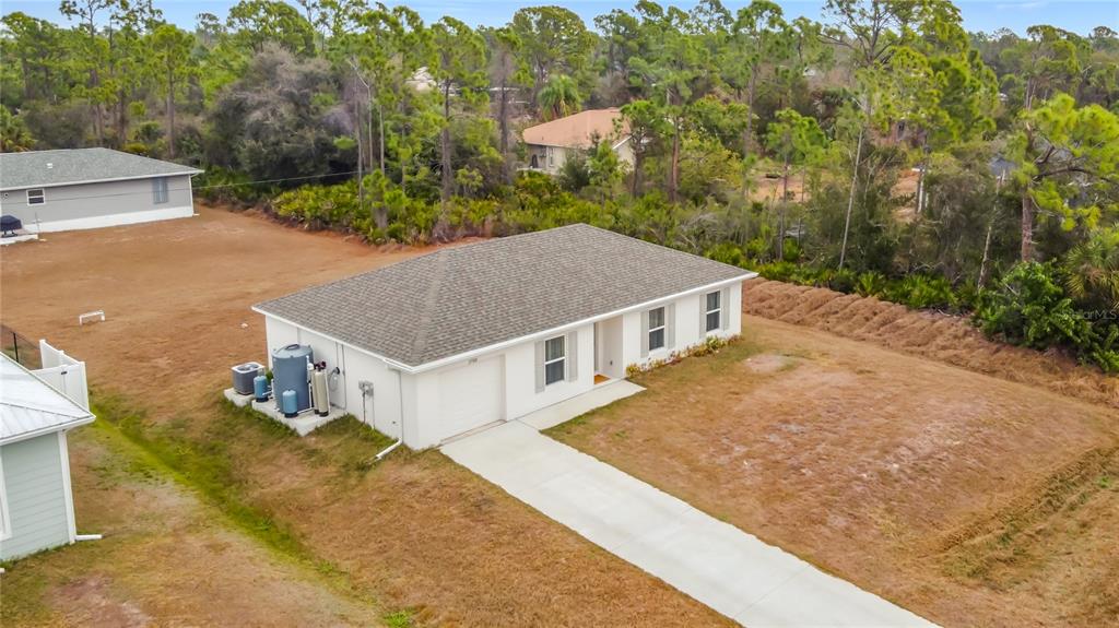 An aerial view shows a single-story white house with a gray roof and concrete driveway — 23300 AIRWAY AVENUE, PORT CHARLOTTE, FL