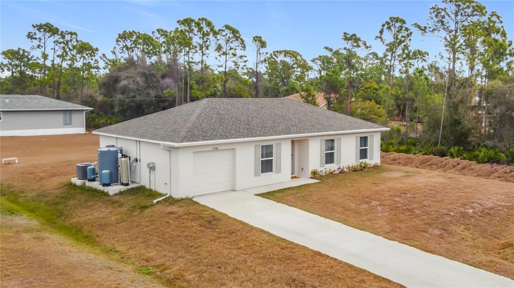 A single-story house with a white exterior, a garage, and a concrete driveway — 23300 AIRWAY AVENUE, PORT CHARLOTTE, FL