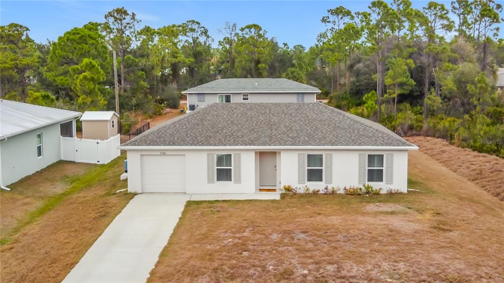 A single-story white house with a gray roof, a garage, and a concrete driveway — 23300 AIRWAY AVENUE, PORT CHARLOTTE, FL