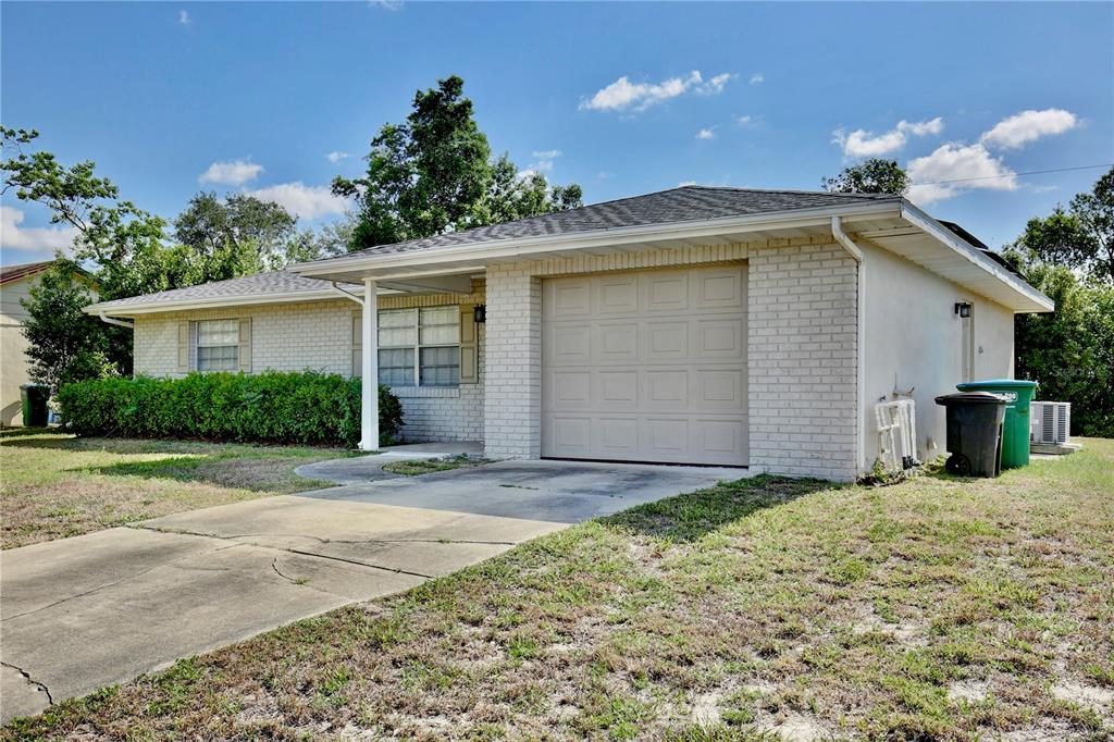 A single-story brick house features a one-car garage, a concrete driveway, and a front lawn — 1847 FAYETTEVILLE AVE, DELTONA, FL
