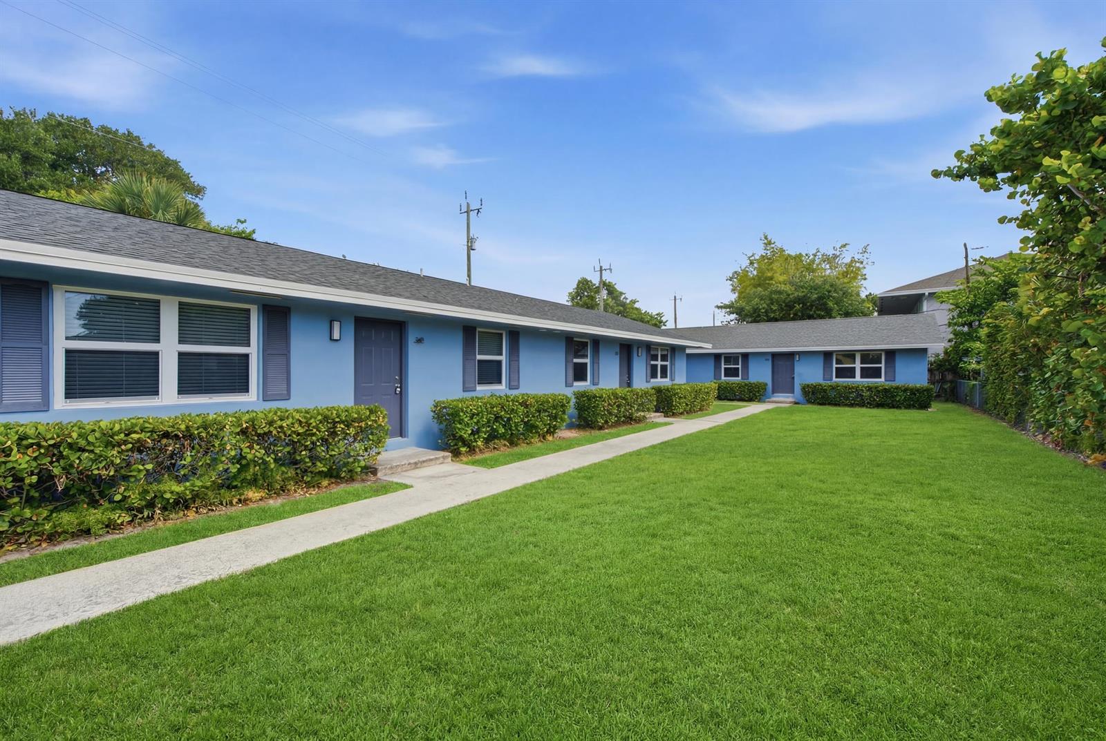 A blue, single-story apartment building with a concrete walkway and a large green lawn — 355 Wickline Boulevard, Lantana FL 33462, LANTANA, FL