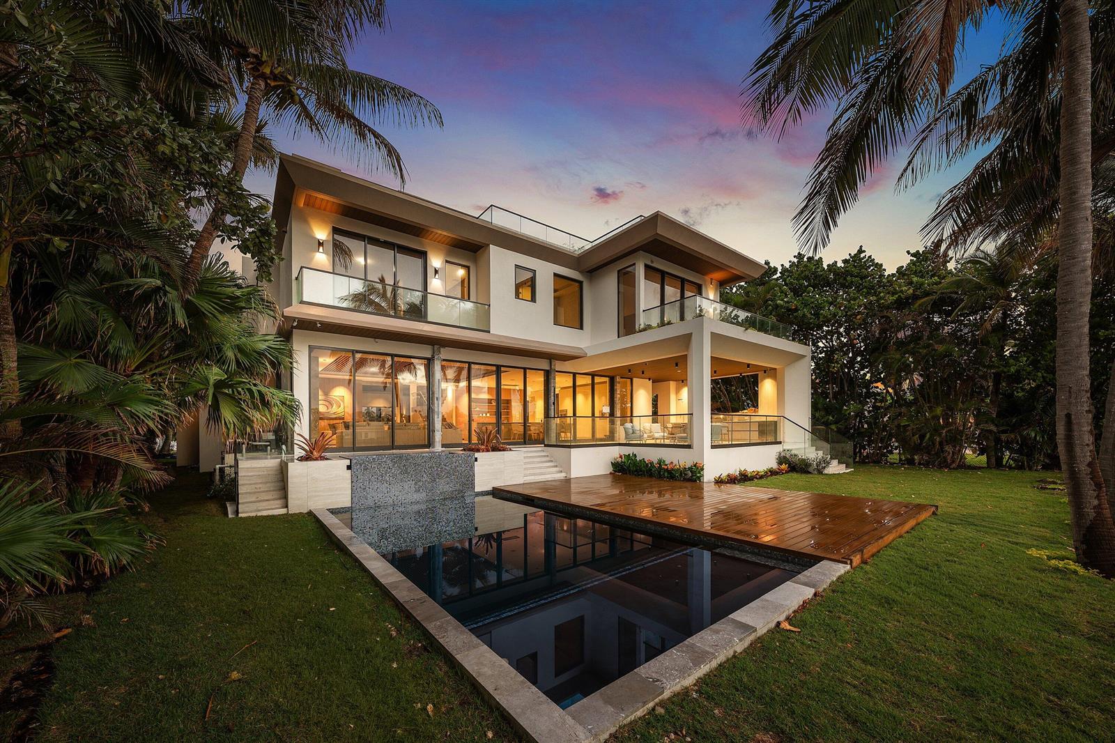 A modern two-story house with a swimming pool, wooden deck, and large glass sliding doors — 5 Barefoot Lane, Lantana FL 33462, LANTANA, FL