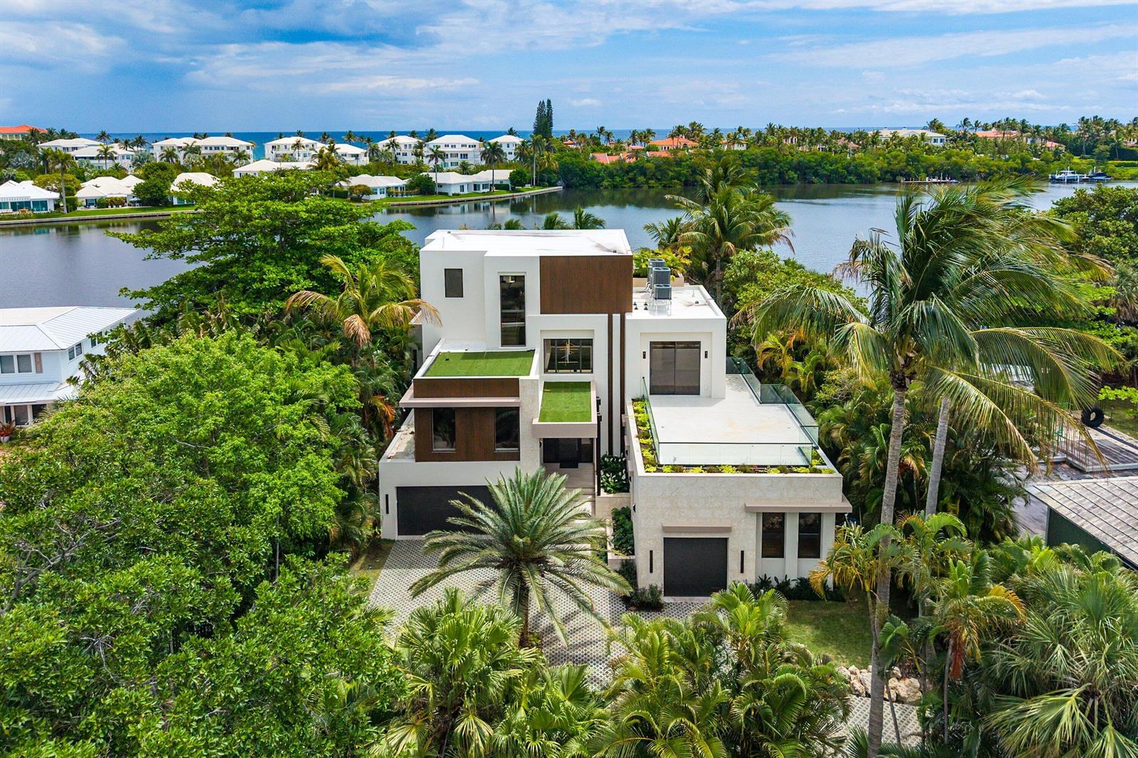 An aerial view of a modern multi-story house with flat roofs, green terraces, and palm trees — 5 Barefoot Lane, Lantana FL 33462, LANTANA, FL