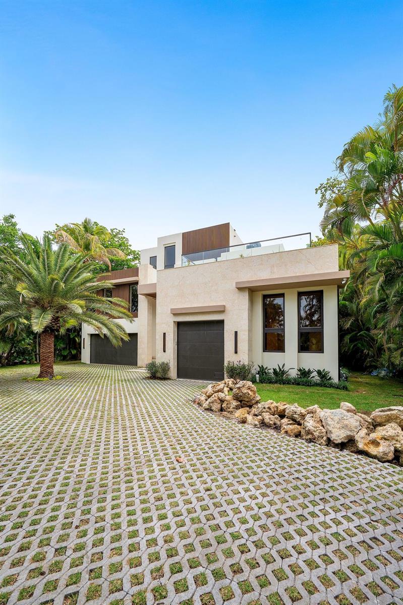 A modern two-story house with a stone facade, a paved driveway, and surrounding palm trees — 5 Barefoot Lane, Lantana FL 33462, LANTANA, FL