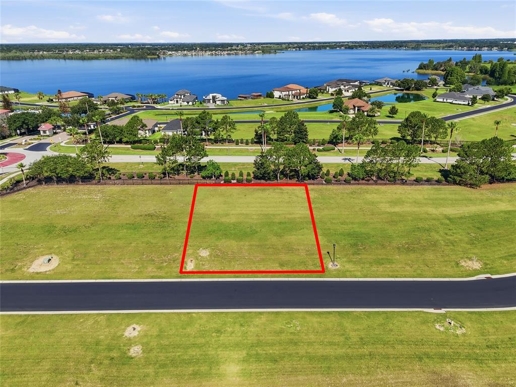 An aerial view shows a vacant rectangular lot outlined in red next to a road — 500 BONAMIA AVENUE, LAKE ALFRED, FL