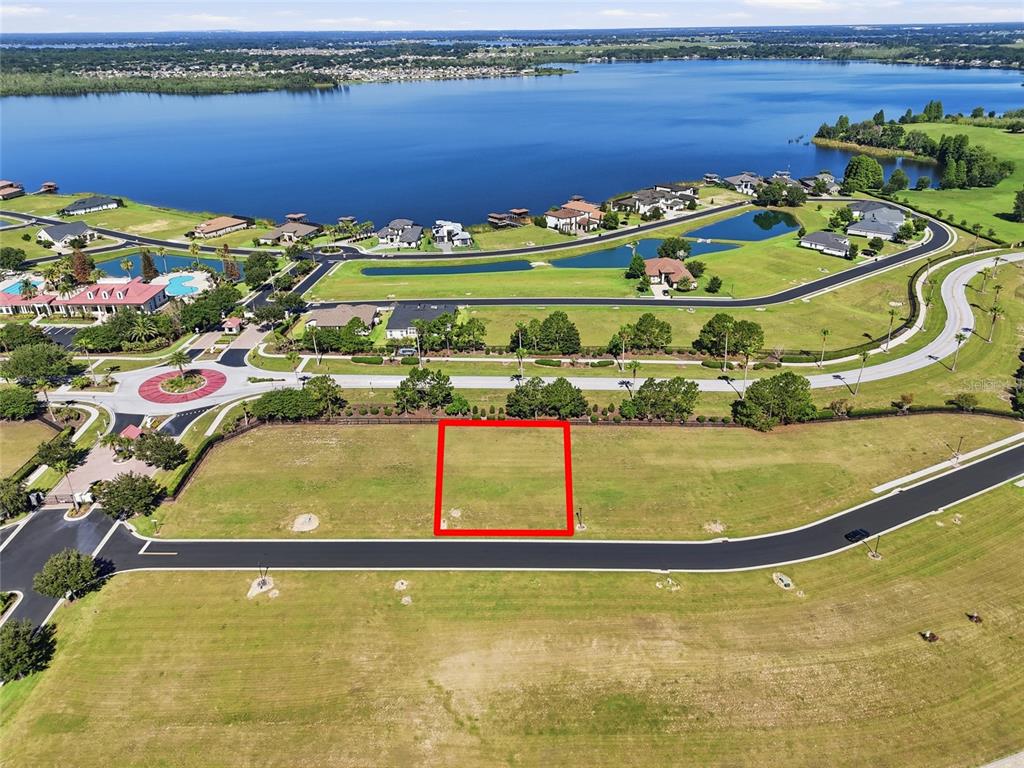 An aerial view shows a vacant residential lot outlined in red within a suburban community — 500 BONAMIA AVENUE, LAKE ALFRED, FL