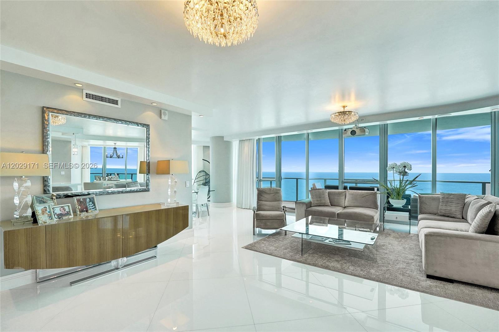A bright living room features white tile floors, a large mirror, and floor-to-ceiling ocean views — 3101 S Ocean Dr # 2208, Hollywood FL 33019, HOLLYWOOD, FL