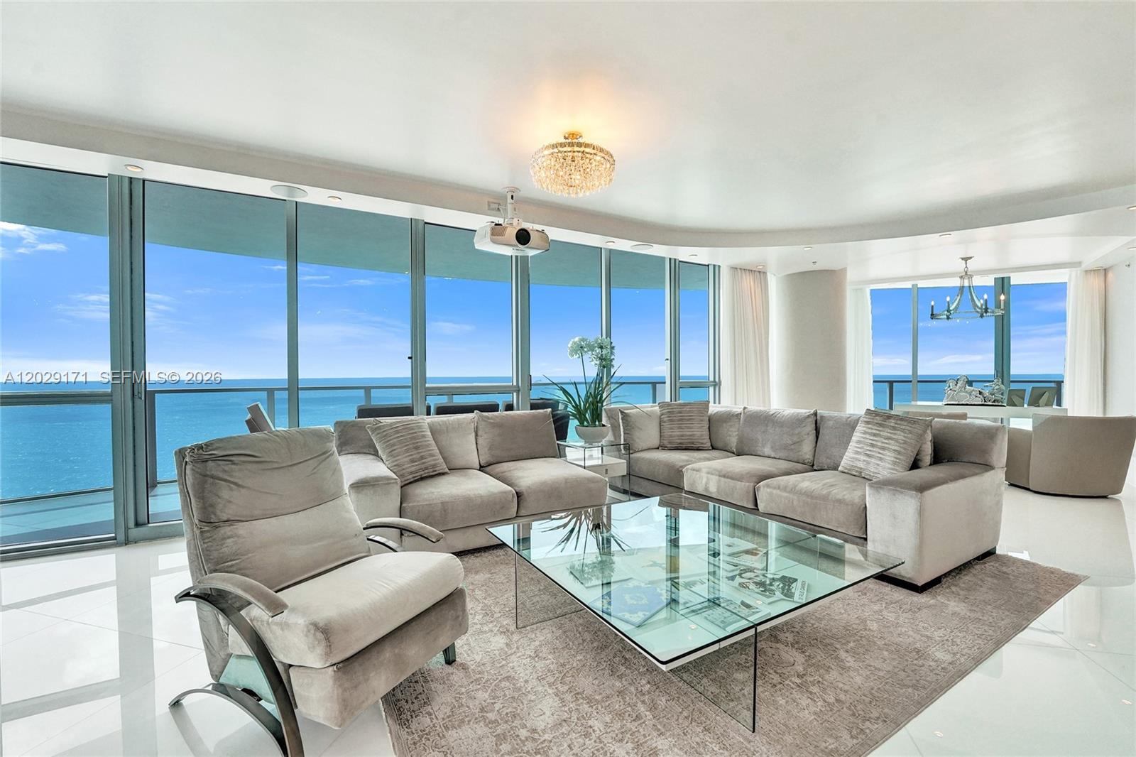 A modern living room features a large sectional sofa, glass coffee table, and floor-to-ceiling windows — 3101 S Ocean Dr # 2208, Hollywood FL 33019, HOLLYWOOD, FL