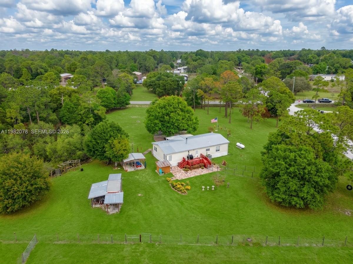 An aerial view shows a single-story house with a red deck on a large grassy lot — 1700 Tampa Ave, Clewiston FL 33440, CLEWISTON, FL