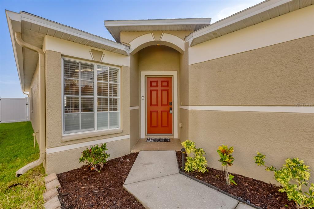 A covered patio with a brick paver floor overlooks a lake and a white fence — 31209 MASENA DRIVE, WESLEY CHAPEL, FL