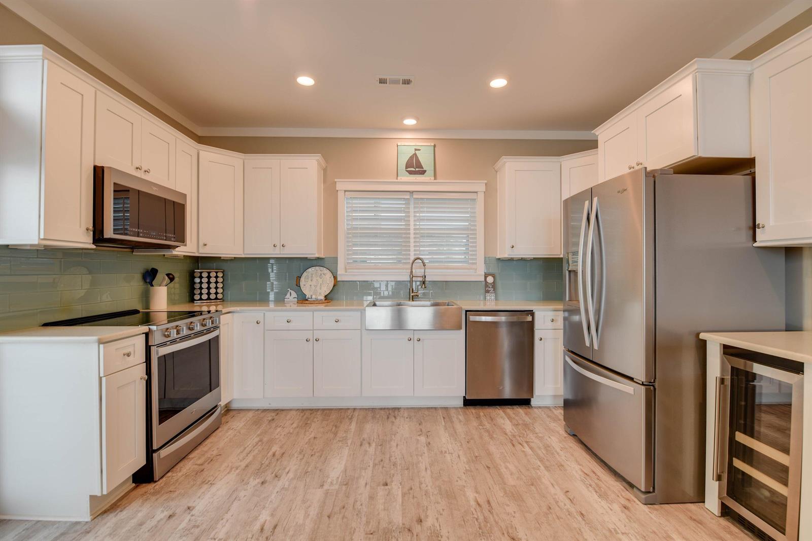A kitchen featuring white cabinets, stainless steel appliances, a farmhouse sink, and light wood flooring — 101 11th Street # 35, Marathon FL 33050, MARATHON, FL