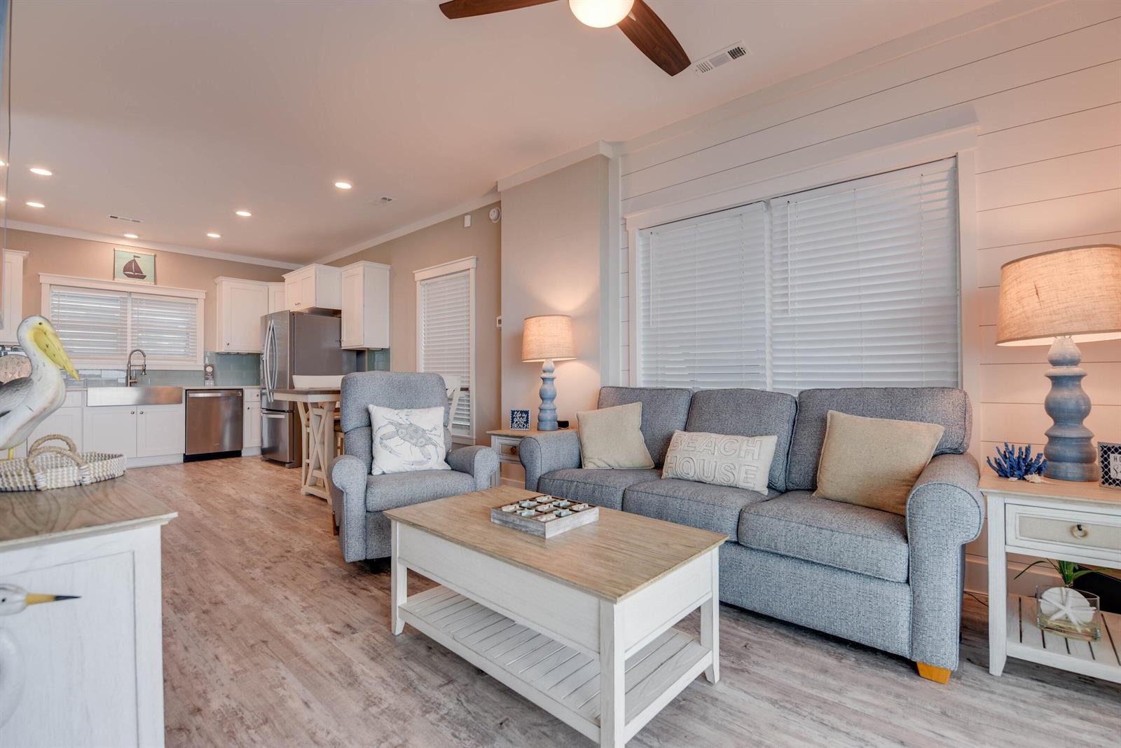 A living room with a gray sofa, armchair, and coffee table opens to a kitchen — 101 11th Street # 35, Marathon FL 33050, MARATHON, FL